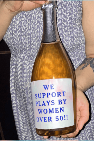 The "We Support Plays by Women Over 50" bubbly bottle